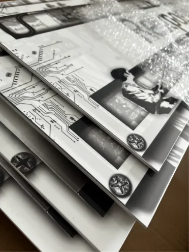 Schilder Gestapelte, bedruckte Blätter mit Schwarz-Weiß-Motiven und filigranen Details.