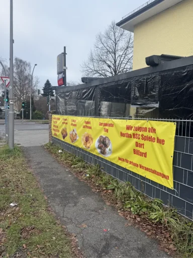 PVC-Banner Bunte Werbebanner mit Speiseangeboten an einer ummauerten Fläche.