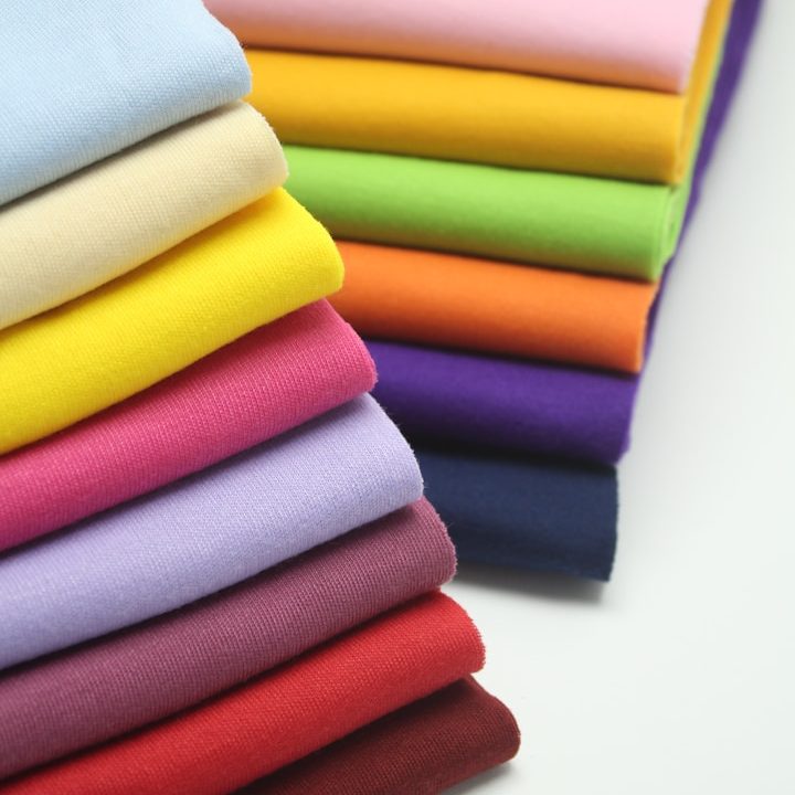 Mehrere übereinander liegende Stoffstücke in verschiedenen bunten Farben.