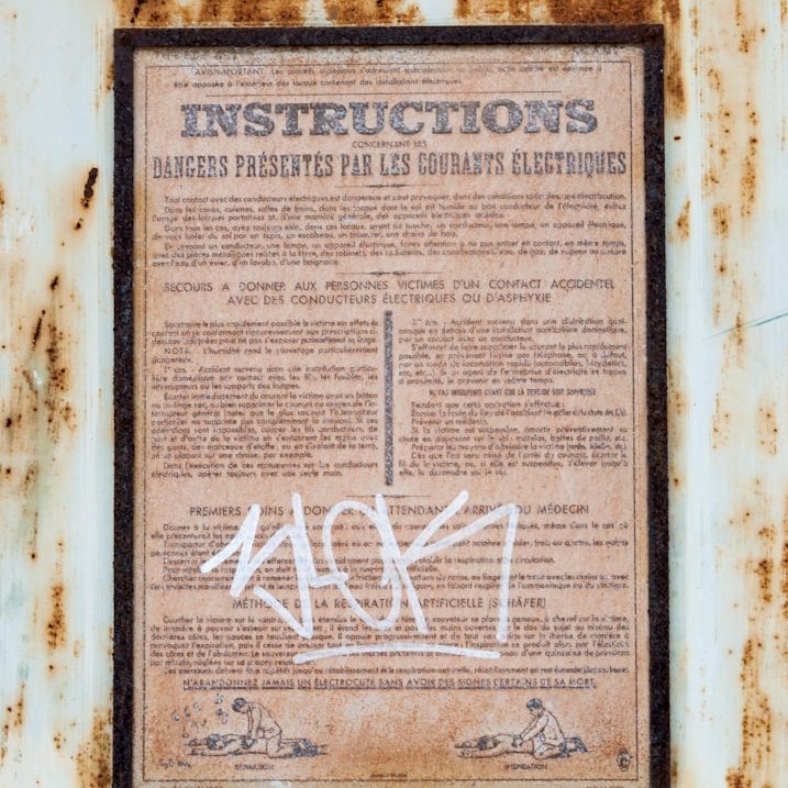 Alte, beschriftete Anweisung auf Papier, verziert mit Graffiti.