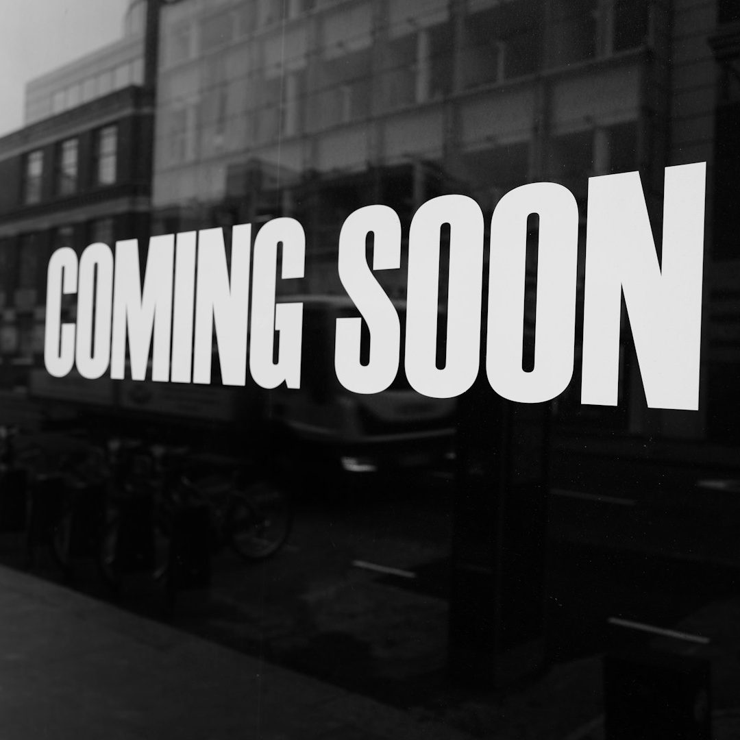 Schaufensterfolierung & Glasdesign Weißer Schriftzug "COMING SOON" auf Schaufensterscheibe, welche auch reflektiert.