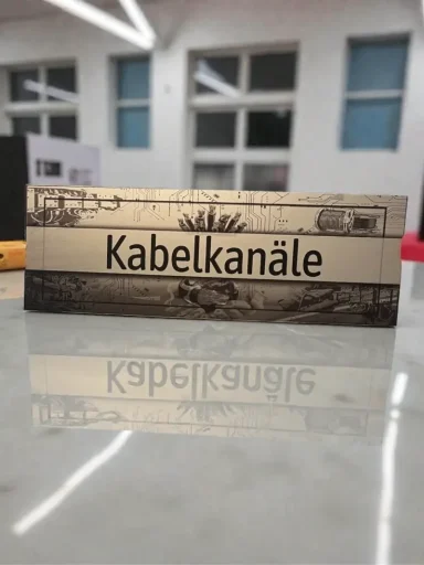 Schild Schild mit der Aufschrift "Kabelkanäle", auf reflektierendem Untergrund.