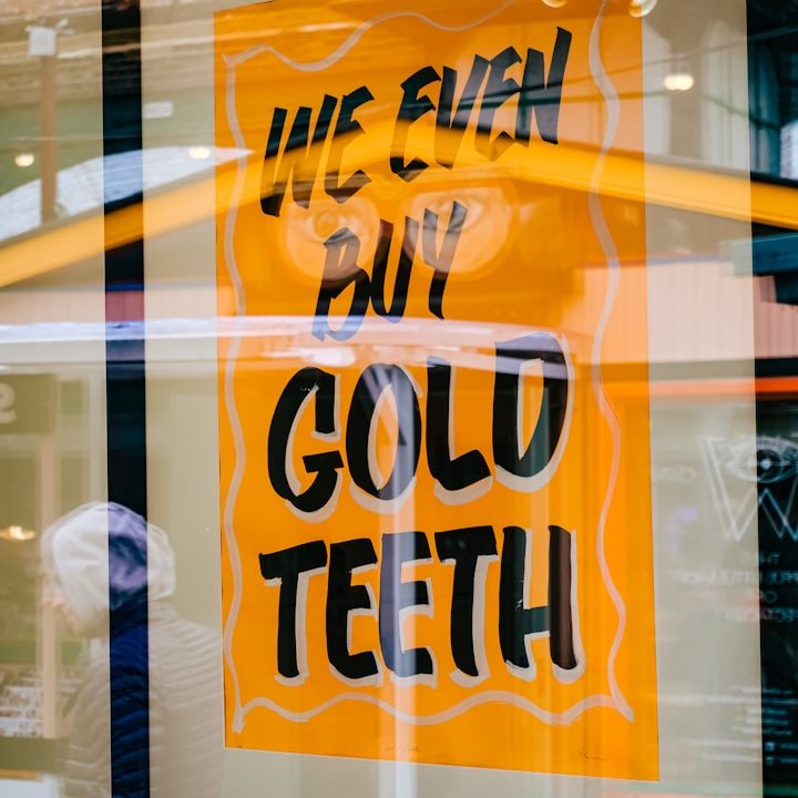 Warum Sokiki Design für Werbetechnik? Werbeschild in Orange mit der Aufschrift „Wir kaufen sogar Goldzähne“.