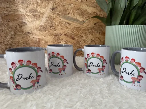 Vier Tassen mit bunten, kindlichen Illustrationen und dem Schriftzug "Du bist".