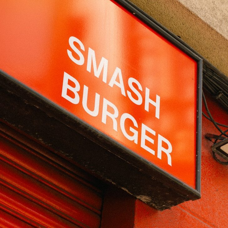 Sign mit der Aufschrift "SMASH BURGER" auf rotem Hintergrund.