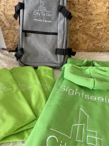 Grauer Rucksack und grüne Taschen mit dem Aufdruck "sightseeing".
