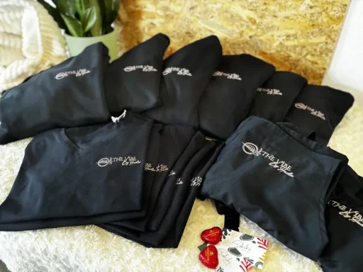 Mehrere schwarze Taschen mit weißen Schriftzügen, angeordnet auf einer Oberfläche.