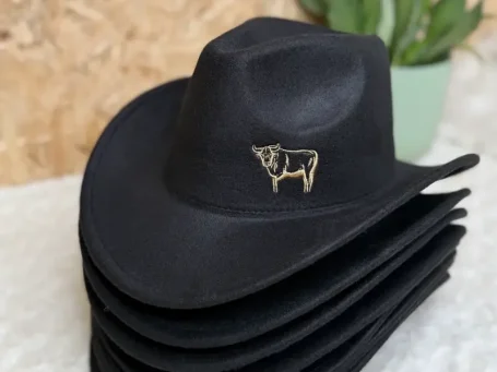 Schwarzer Cowboyhut mit goldener Kuhstickerei, übereinander gestapelt.