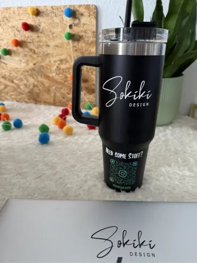 Schwarzer Becher mit "Sikiki" Schriftzug und einem Deckel mit Strohhalm.